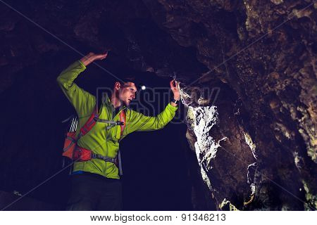 Man Exploring Underground Dark Cave Tunnel