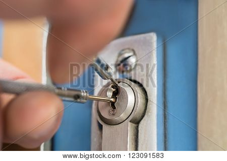 Close-up Of Lockpicker Hand Fixing Door Handle At Home