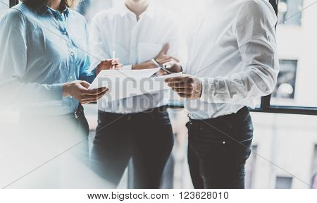 Business team meeting, work process. Photo professional crew working with new startup project. Project managers near window. Analyze business plans. Blurred background, film effect, bokeh.