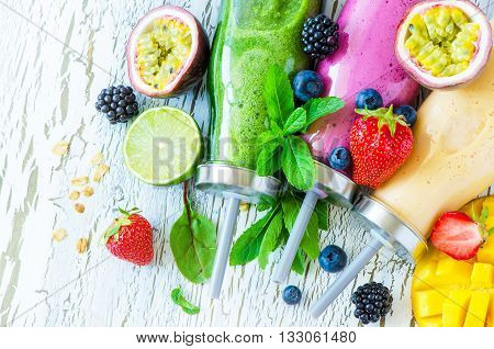 Berry and fruit smoothie in bottles healthy summer detox yogurt drink diet or vegan food concept fresh vitamins mango lime