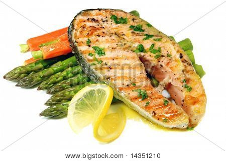 Grilled salmon cutlet with asparagus and baby carrots, and a butter and parsley sauce.