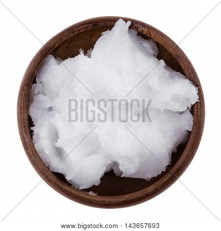 Coconut oil in a bowl on white background. Also copra oil, an edible oil, extracted from the kernel of meat of mature coconuts harvested from the coconut palm, Cocos nucifera. Isolated macro photo.