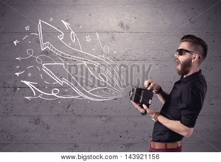 A hipster guy opening his point of view through looking a vintage camera concept with illustratied drawn arrows on urban wall