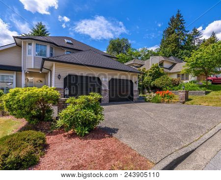 A perfect neighborhood. Houses in suburb at Summer in the north America. Fragment of a luxury house with nice window over blue sky.