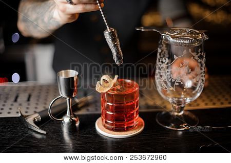 Bartender Making A Fresh And Sweet Orange Summer Cocktail Using Professional Bar Equipment On The Co