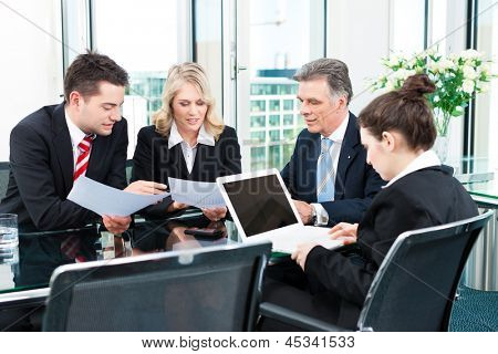 Business - meeting in an office, the businesspeople are discussing a document