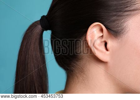 Woman On Light Blue Background, Closeup Of Ear