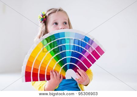 Little Girl Choosing Paint Color For Wall