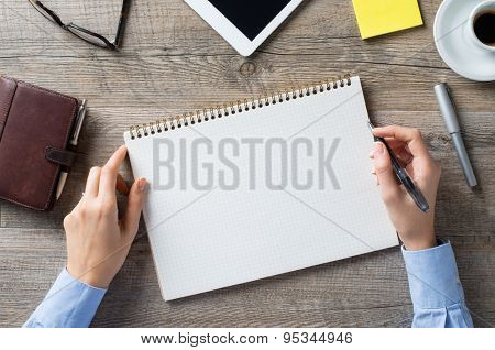 Closeup shot of a woman taking down note in a personal organizer. Business woman is writing in a diary in her office. Blank page to write it on your own message.
