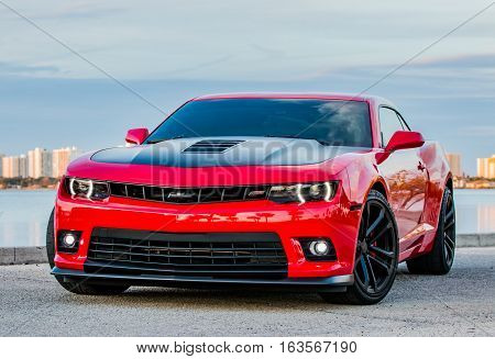 December 31, 2016 - Port Orange, Florida. Shiny Red and Black Chevrolet Camaro SS parked along the river. This is the 6th Generation Chevy Camaro SS. The 5th Generation SS has a 6.2L V8 and began sales in 2015 for the 2016 model year.