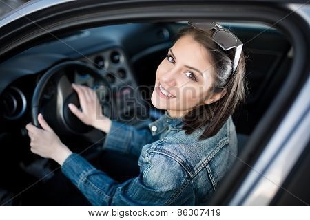 Happy woman in new car.Young woman in car going on road trip.Student driving car.Driver license exam