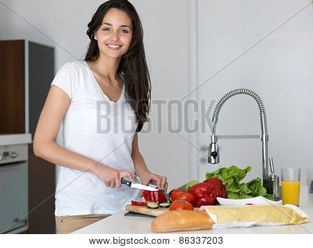 Young Woman Cooking in the kitchen. Healthy Food - Vegetable Salad. Diet. Dieting Concept. Healthy Lifestyle. Cooking At Home. Prepare Food