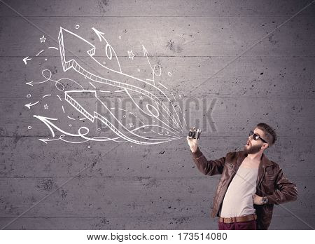 A hipster guy opening his point of view through looking a vintage camera concept with illustratied drawn arrows on urban wall