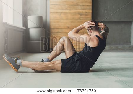 Young man workout in fitness club. Closeup portrait of caucasian guy making exercise, sit-ups and cross crunches for abs muscles, training indoors