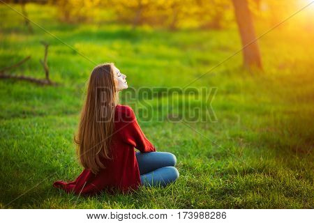 Portrait of happy sporty woman relaxing in park. Joyful female model breathing fresh air outdoors. Healthy active lifestyle concept