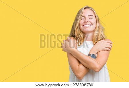 Beautiful young elegant woman over isolated background Hugging oneself happy and positive, smiling confident. Self love and self care