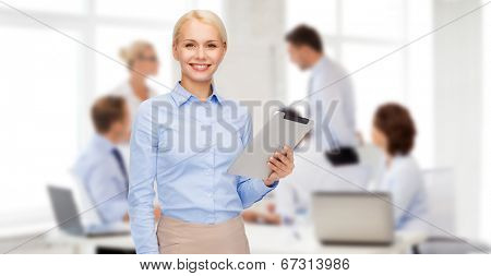 business, internet and technology concept - smiling woman looking at tablet pc computer