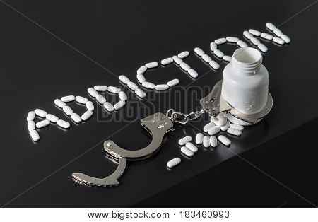 Get addicted to drugs or free from addiction to medicine. Drug and narcotics abuse or after rehab concept. Addiction written with pills. Medicine spilling out from a bottle locked with open handcuffs.