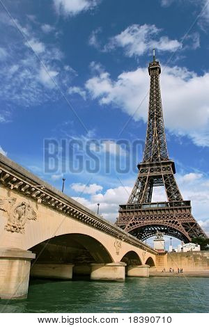 Vertical oriented photo of Eiffel Tower and fragment of bridge over the Seine River in Paris, France.