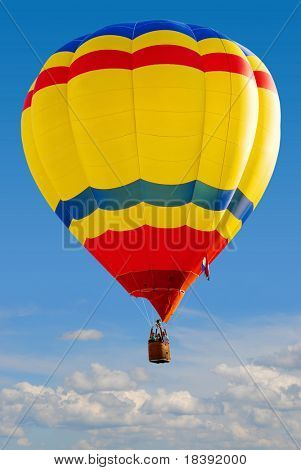 colorful hot air balloon above the clouds with clear blue sky background