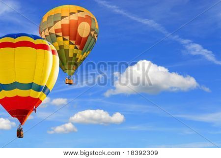 two colorfull hot air balloons floating in blue sky background