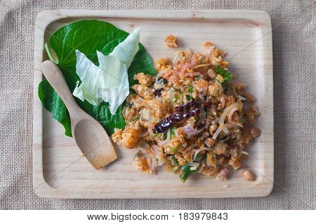 Yam Naem Khao Thot Thai style food on wood tray