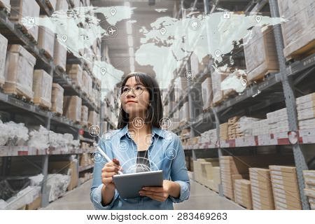 Portrait Of Happy Young Attractive Asian Entrepreneur Woman Looking At Inventory In Warehouse Using 