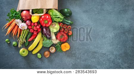 Healthy food selection. Shopping bag full of fresh vegetables and fruits. Flat lay food on table