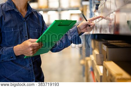 Manager Man Worker Doing Stocktaking Of Product Management In Cardboard Box On Shelves In Warehouse.