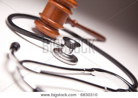 Gavel And Stethoscope On Gradated Background