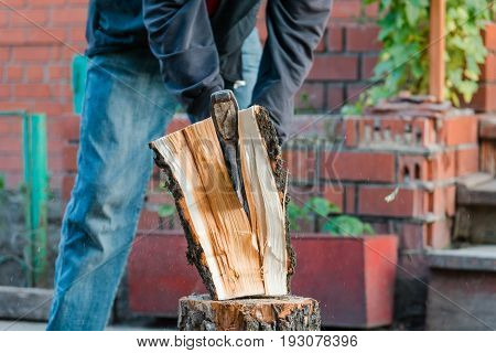 Splits Firewood The Axe. The Man Splits The Axe Wood.