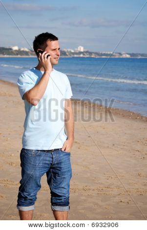 Uomo con mobile sulla spiaggia