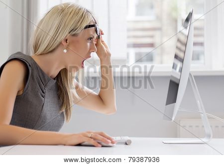 Shocked woman looking at computer