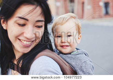 Beautiful Asian Mother With Her Blond Son Relaxing Outdoors. Unusual Appearance, diversity Concept