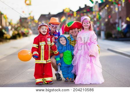 Kids And Parents On Halloween Trick Or Treat