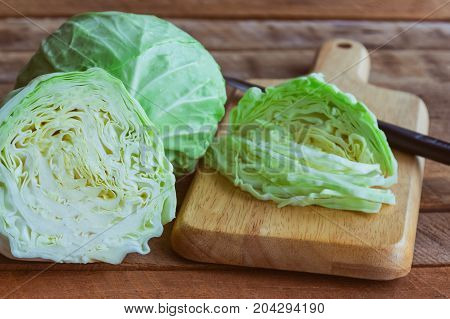 Chopped fresh cabbage on wood cutting board for food. Use knife kitchen cutting cabbage prepare for cooking. Cut or sliced fresh cabbage to shredded for coleslaw salad or other food. Sliced or chopped cabbage prepare for cooking.