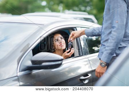 Buying used car. Car Dealer Inventory. Used cars store. Male wants to buy the car. Close-up of hand with a wrist watch, holding key from auto, finance for car concept. Happy life. Blurred background.