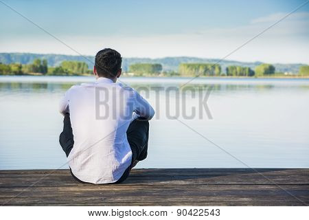 Handsome young man on a lake in a sunny, peaceful day