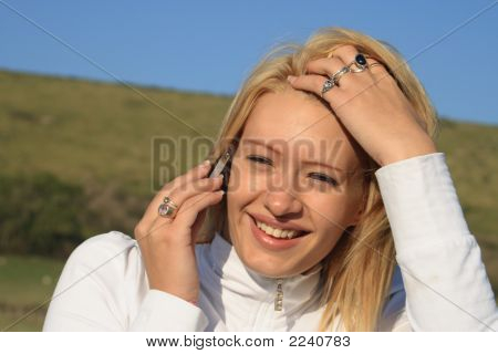 Young Woman On Her Mobile In A Field