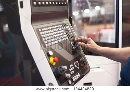 Operator working at programmable machine. CNC machine.