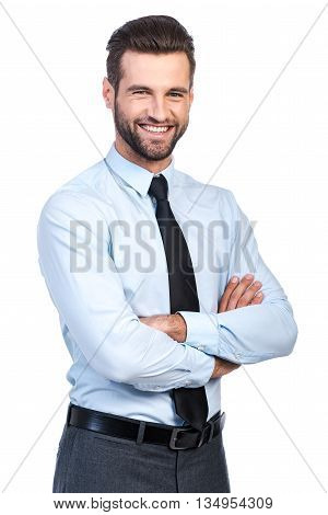 Confident business expert. Confident young handsome man in shirt and tie keeping arms crossed and smiling while standing against white background