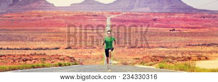 Runner man running sprinting on road of mountain nature. Male sprinter training for success. Fit sports athlete working out in amazing desert landscape. Panorama banner with copy space on background.