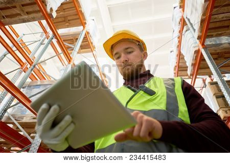 Low Angle Portrait Of Warehouse Worker Holding Digital Tablet  While Doing Stock Inventory, Copy Spa