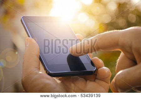 Close up of a man using mobile smart phone outdoor