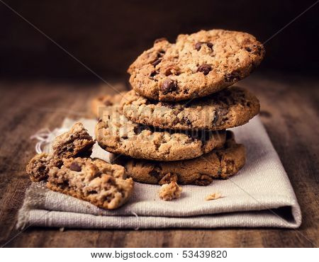 Chocolate Chip Cookies On Linen Napkin On Wooden Table. Stacked Chocolate Chip Cookies Close Up.