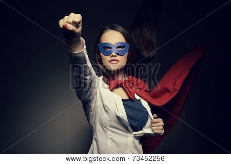 Young pretty woman opening her shirt like a superhero. Super girl, image toned. Beauty saves the world.