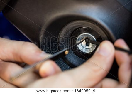 Close-up Of A Person's Hand Inserting Lockpickers Tools In Key Hole