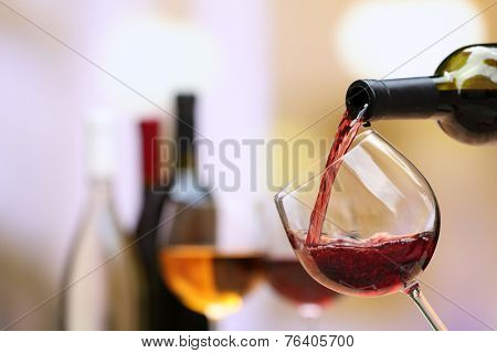 Red wine pouring into wine glass, close-up