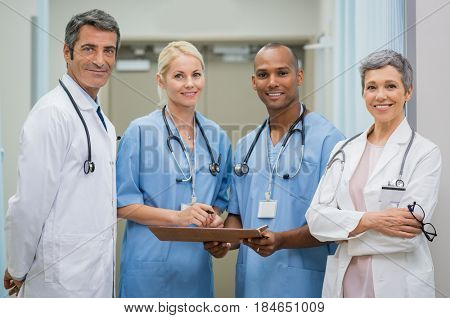 Portrait of cheerful doctors team looking at camera. Smiling team of senior doctors and young nurses at hospital. Portrait of confident happy multiethnic group of doctors at medical clinic.