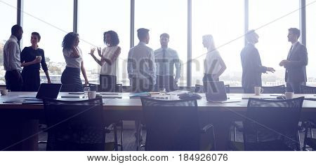 Businesspeople Stand And Chat Before Meeting In Boardroom